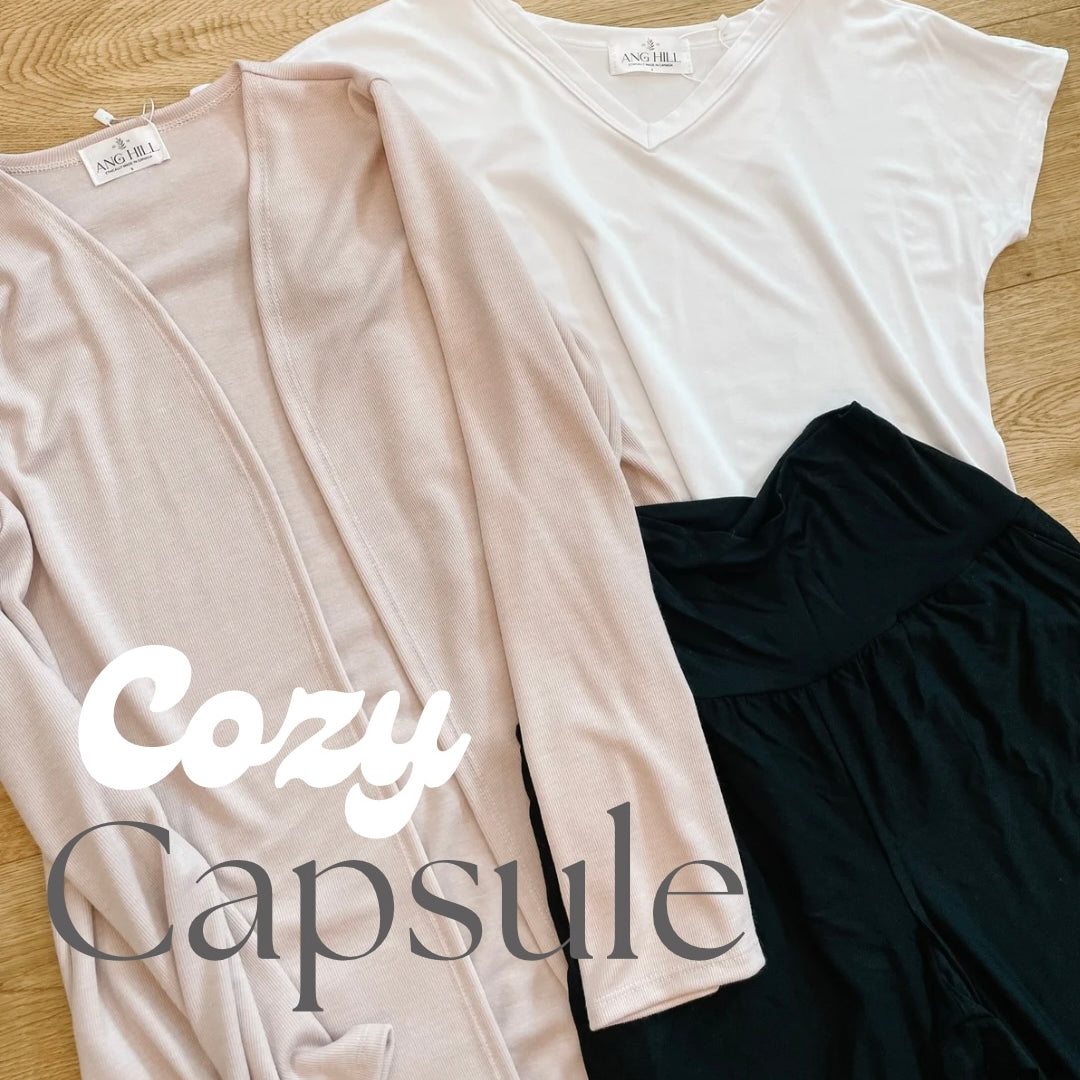 flatlay of pink cardigan white t-shirt and black wide leg pants. cozy capsule text.