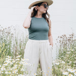 Teal high neck tank top with hat and subglasses and wide leg pants