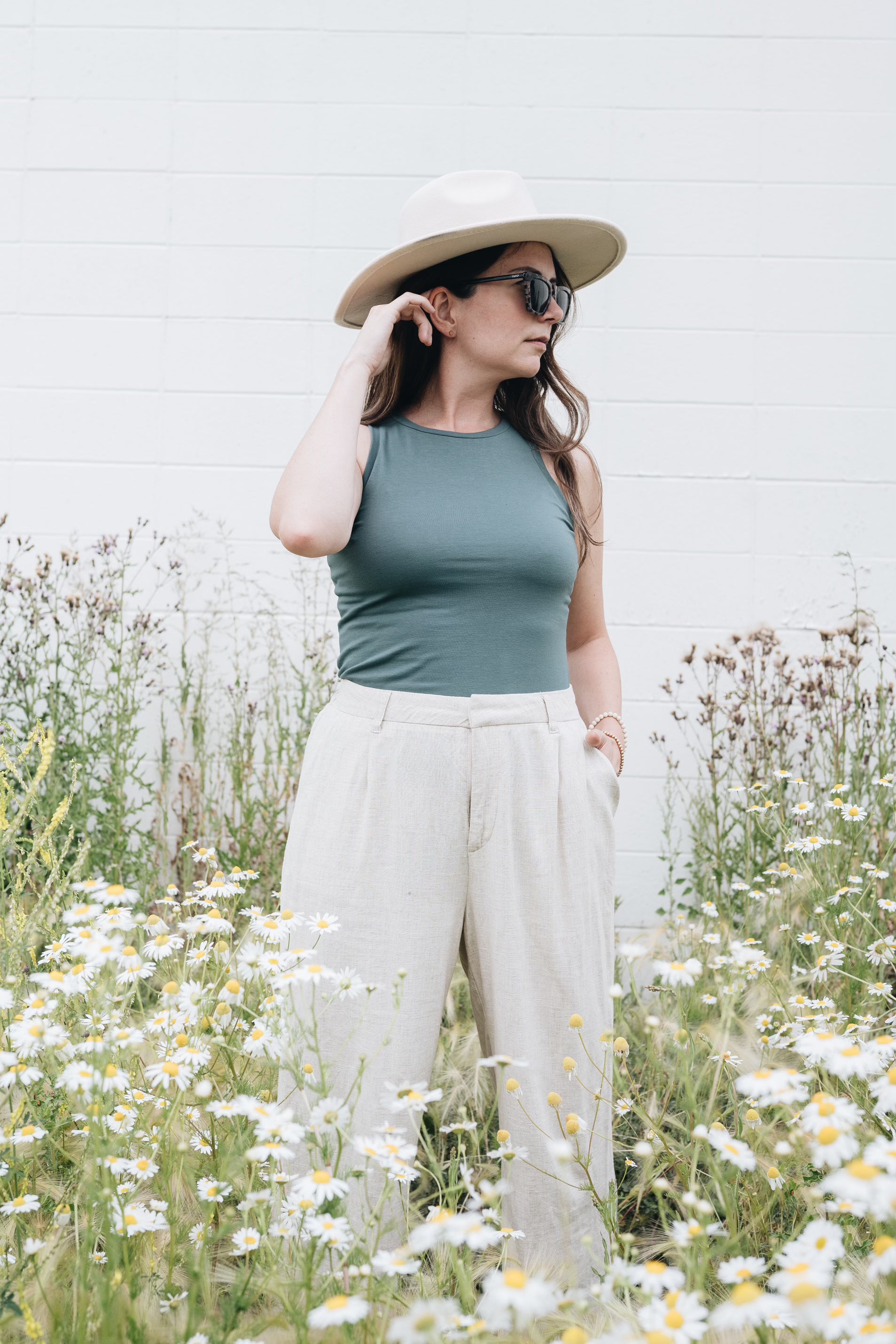 Teal high neck tank top with hat and subglasses and wide leg pants