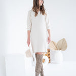 cream sweater dress with knee high boots and hat