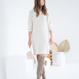 cream sweater dress with knee high boots and hat