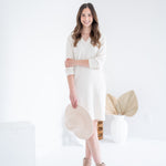 woman wearing cream vneck long sleeved dress with beige hat and beige booties