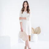 woman wearing cream vneck long sleeved dress with beige hat and beige booties