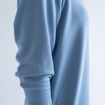 close up of blue long sleeved dress in sky blue