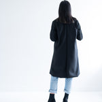 back view of woman wearing black knee length wool coat
