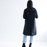 back view of woman wearing black knee length wool coat
