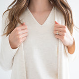 close up of Ang Hill women's cream v-neck sweater paired with long cream cardigan for women