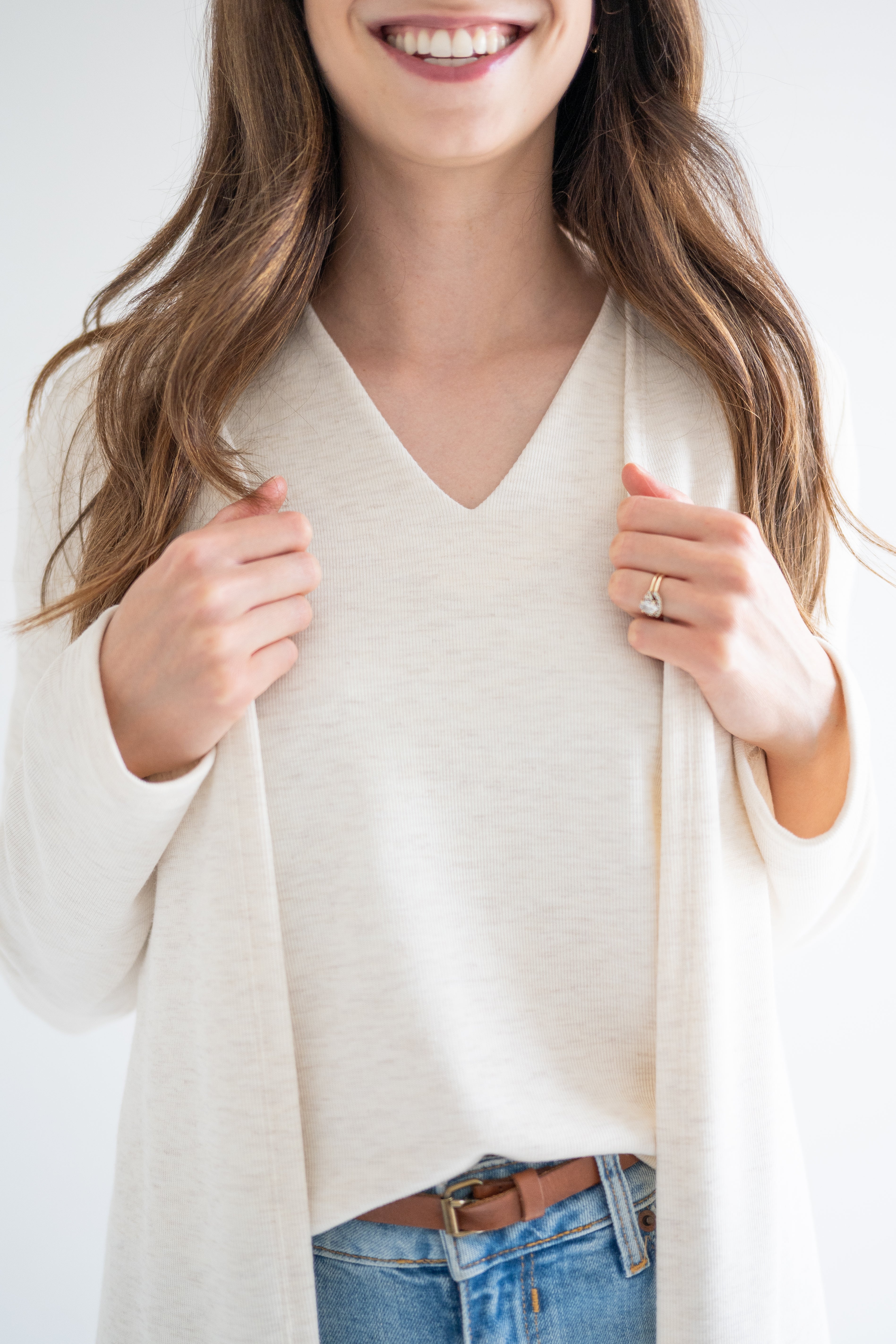 close up of Ang Hill women's cream v-neck sweater paired with long cream cardigan for women