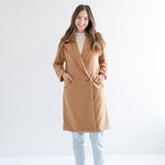 woman wearing camel wool coat with one button and pockets