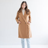 woman wearing camel wool coat with one button and pockets