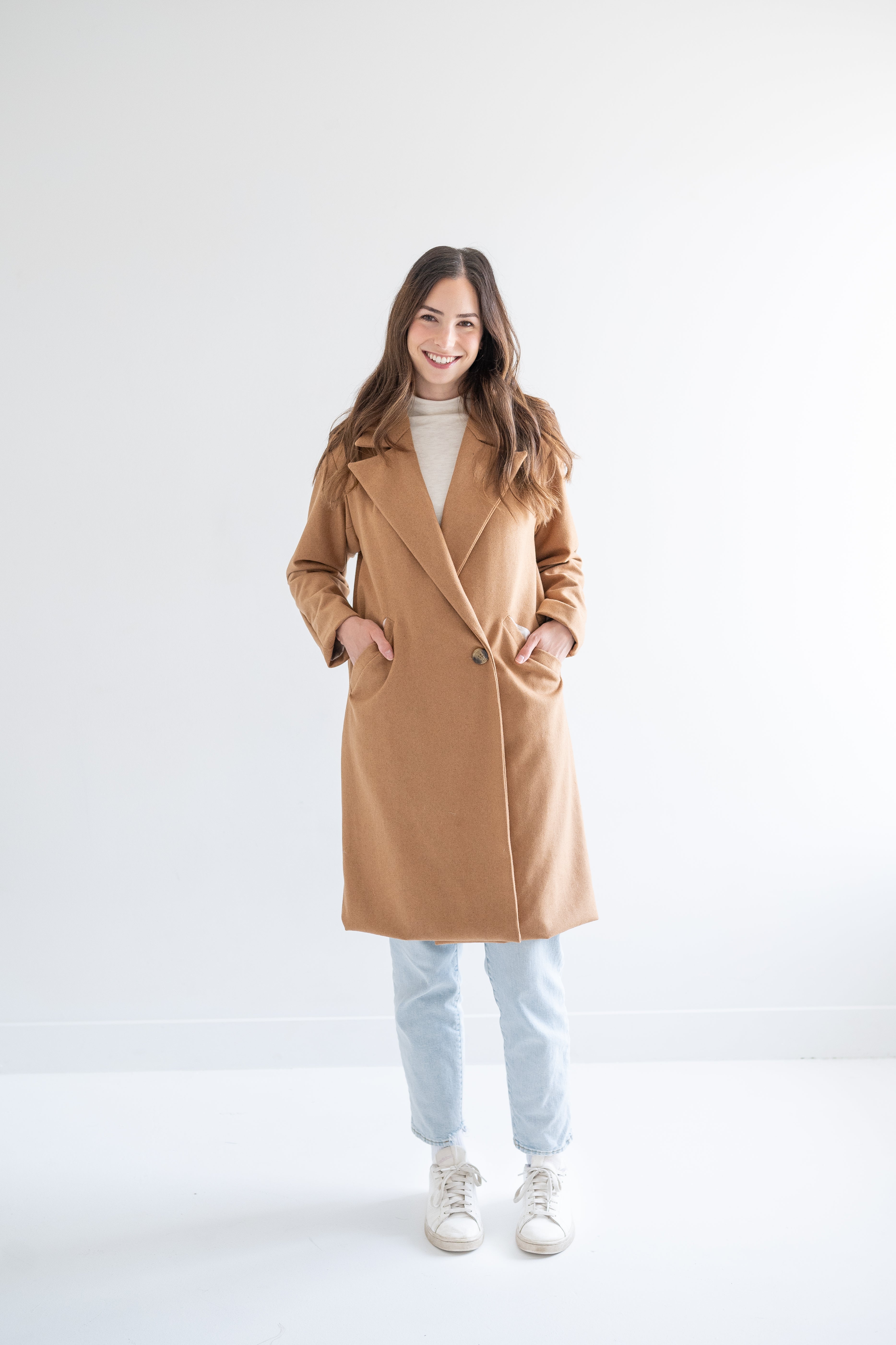 woman wearing camel wool coat with one button and pockets