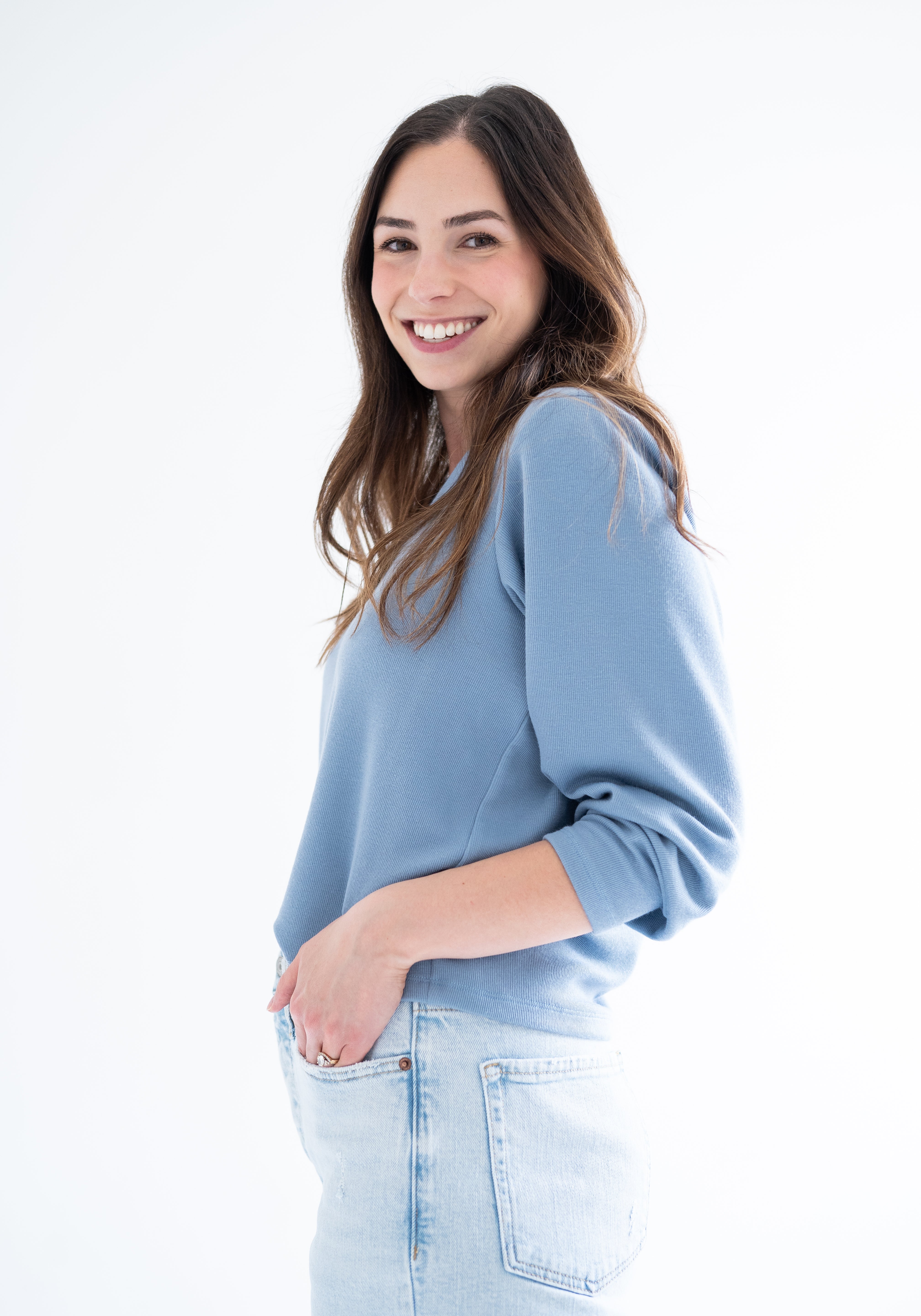 Side view of woman wearing blue v-neck sweater