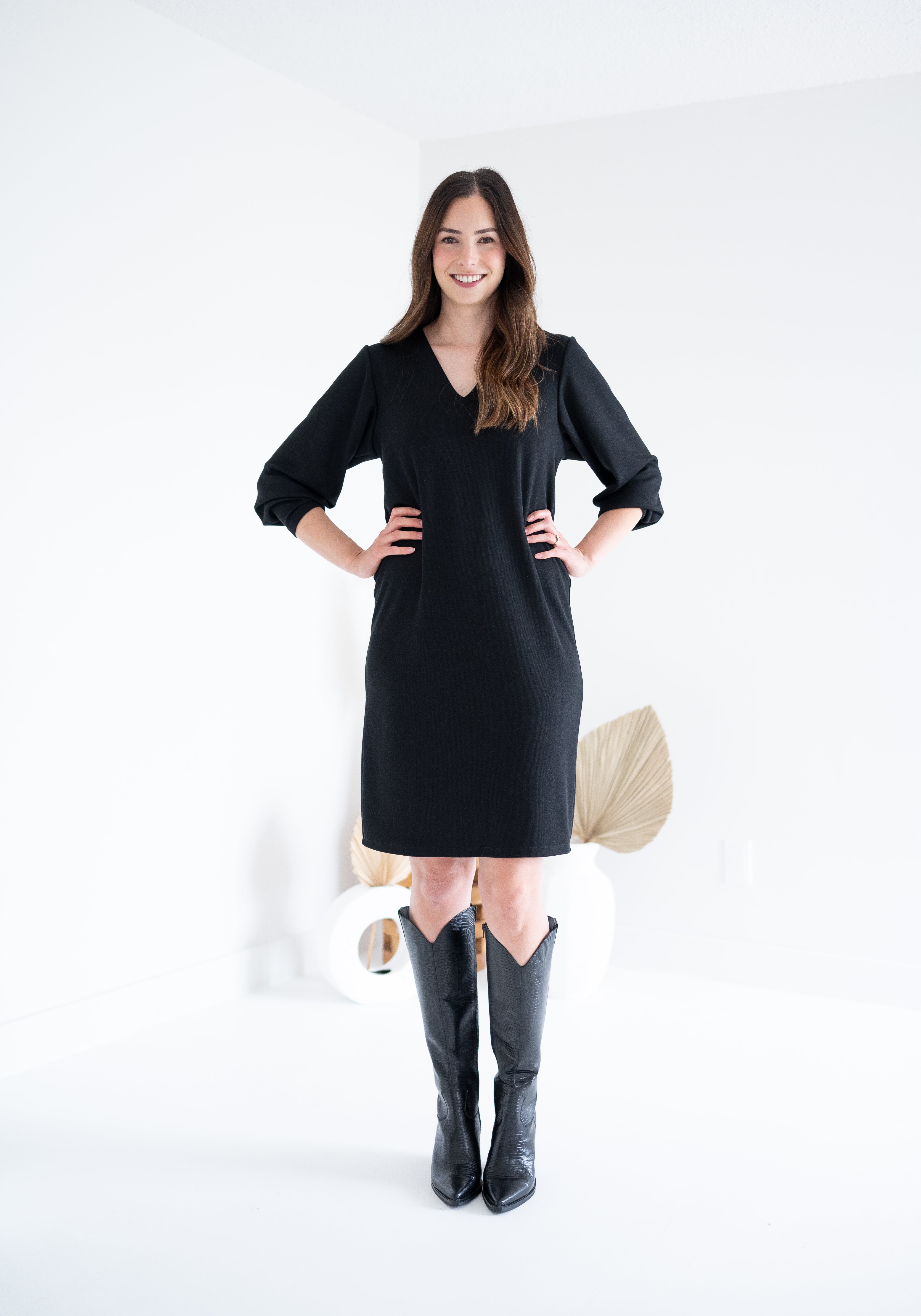 front view of black vneck long sleeved sweater knit dress for women