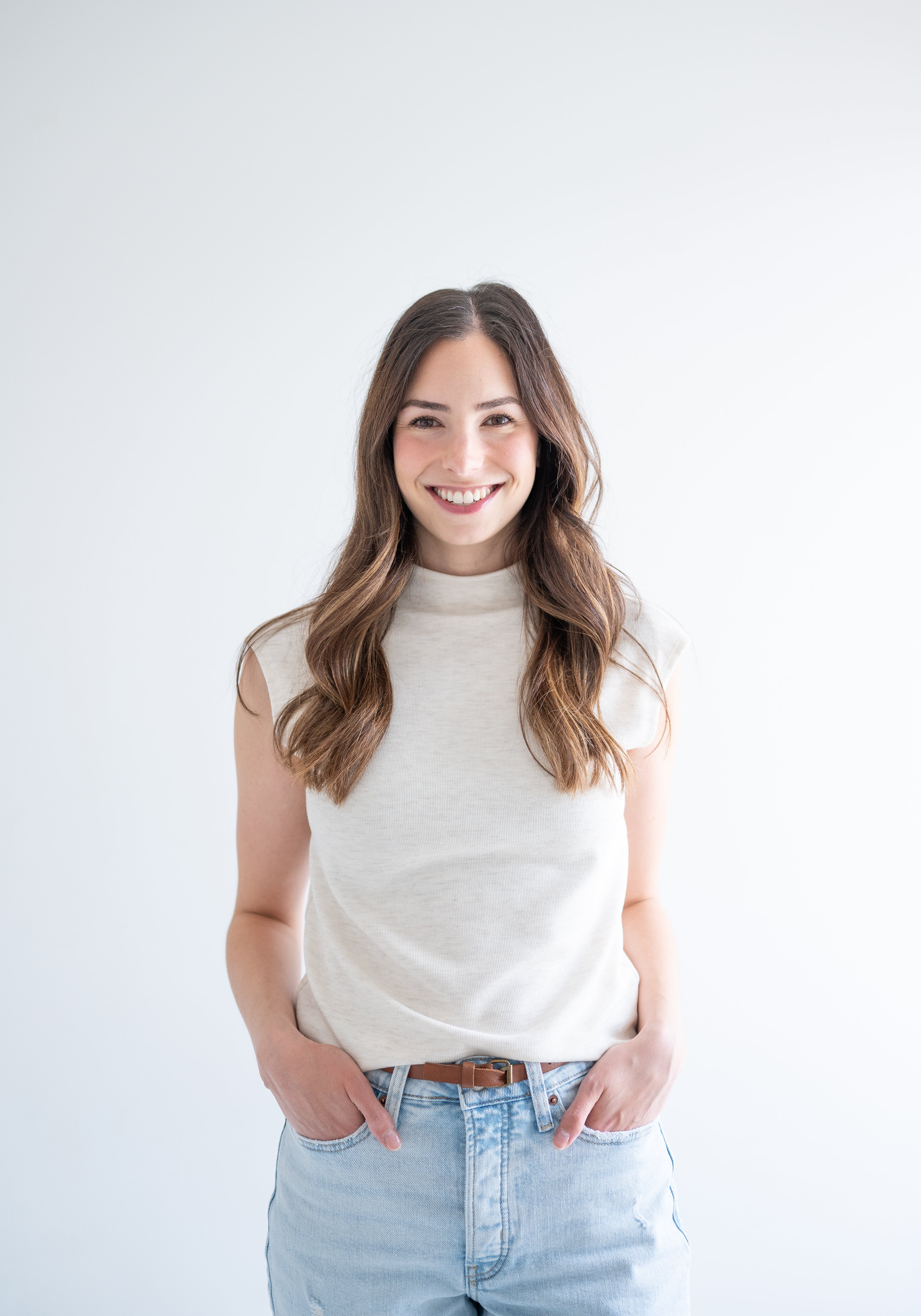 woman wearing cream sleeveless mockneck sweater