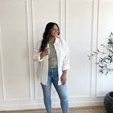 white button down shirt over sage green t-shirt