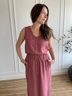 pink loose fitting women's tank top with brown buttons and pink flowy midi skirt with side slits 