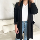 close up of long black shawl cardigan with pockets